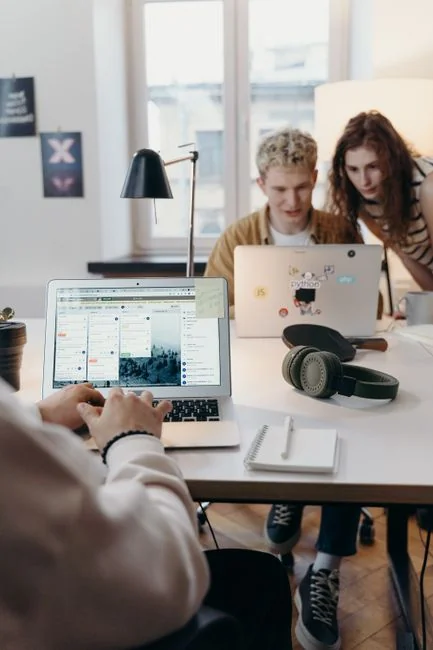 A sleek office desk setup featuring Apple devices: iMac, MacBook, and iPad.